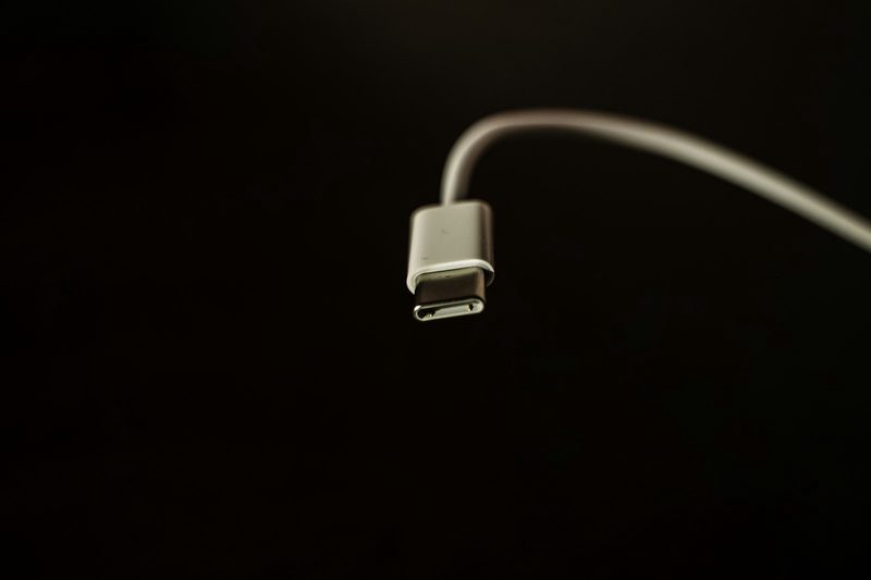 White USB-C cable on a black ground