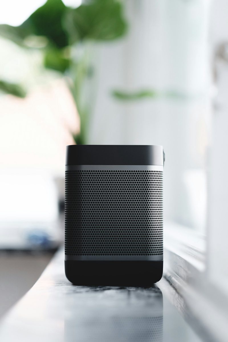 Cylindrical mesh Bluetooth speaker on a windowsill